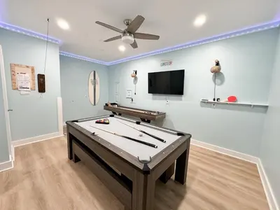 a room with a pool table and a flat screen tv at La Luna in Santa Rosa Beach