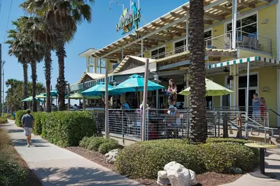 a restaurant with people sitting under umbrellas outside of a building at Laguna Haven! 3BR 2BA Sleeps 7! Your perfect escape! in Panama City Beach