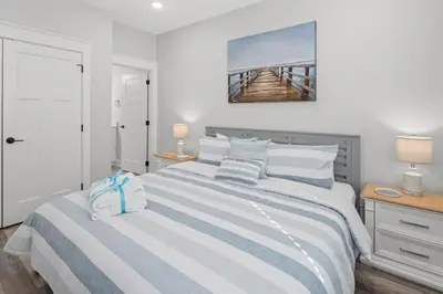 a bedroom with a large bed with blue and white stripes at Laguna Haven! 3BR 2BA Sleeps 7! Your perfect escape! in Panama City Beach