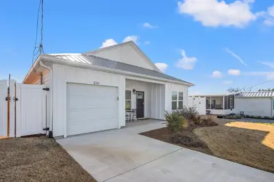a white house with a garage at Laguna Haven! 3BR 2BA Sleeps 7! Your perfect escape! in Panama City Beach