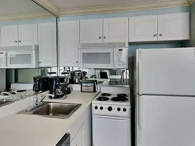 a kitchen with white cabinets and a white refrigerator at Majestic Beach Towers I #312 in Panama City Beach