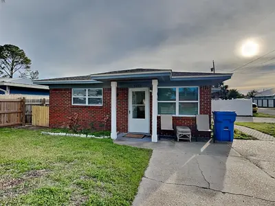 a small red brick house with a white door at Seashell Cottage in Panama City Beach