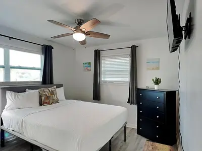 a bedroom with a bed and a ceiling fan at Seashell Cottage in Panama City Beach