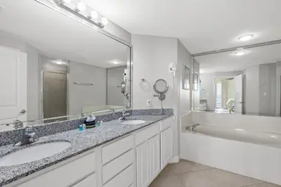 a bathroom with two sinks and a tub and a large mirror at Grandview Oasis! 3BR 2BA Sleeps 9! Gulf-front tranquility beckons! in Panama City Beach