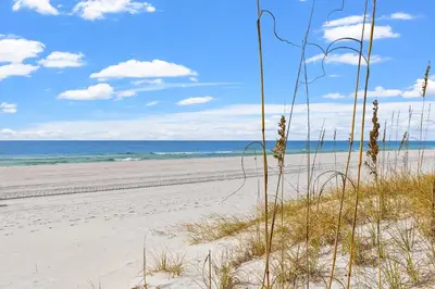 a beach with grass and the ocean in the background at Merrimac Resort #43 in Panama City Beach