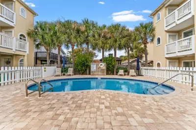 a swimming pool in a courtyard with palm trees at Merrimac Resort #43 in Panama City Beach