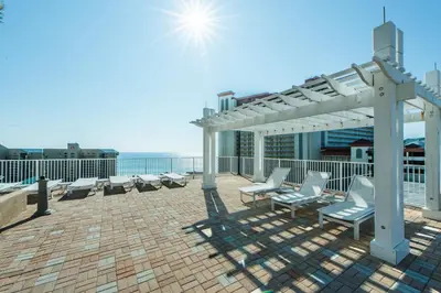 a patio with chairs and a pergola on a roof at Laketown Wharf 801 by Emerald Coast Retreats in Panama City Beach
