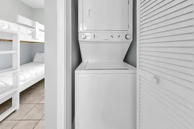 a white laundry room with a washer and dryer at Laketown Wharf 801 by Emerald Coast Retreats in Panama City Beach