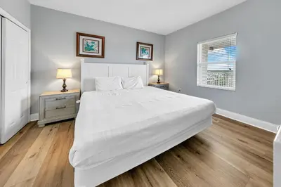 a white bedroom with a large bed and two night stands at Laketown Wharf 801 by Emerald Coast Retreats in Panama City Beach