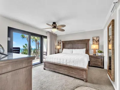 a bedroom with a bed and a balcony at Commodore 203 in Panama City Beach