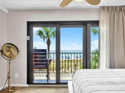 a bedroom with a bed and a view of the ocean at Commodore 203 in Panama City Beach