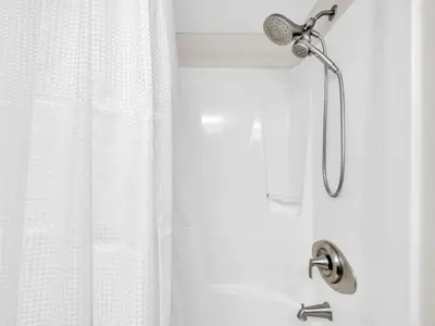 a shower with a shower head and a shower curtain at Commodore 203 in Panama City Beach