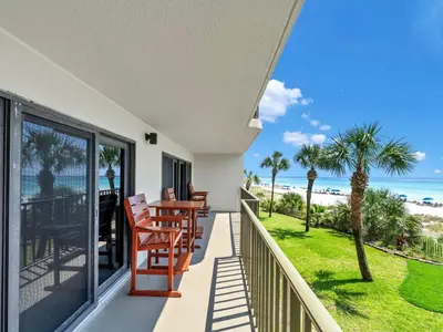 a balcony with a table and chairs and the beach at Commodore 203 in Panama City Beach