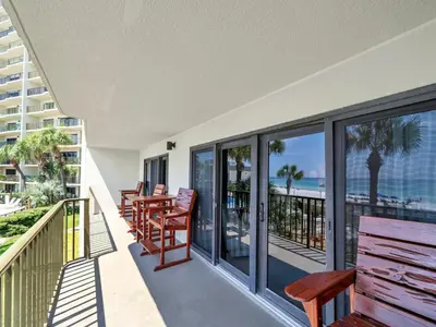 a balcony with benches and a view of the ocean at Commodore 203 in Panama City Beach