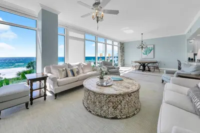 a living room with white furniture and a table at Sterling Beach #301 in Panama City Beach