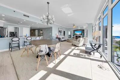 a dining room and living room with a table and chairs at Sterling Beach #301 in Panama City Beach