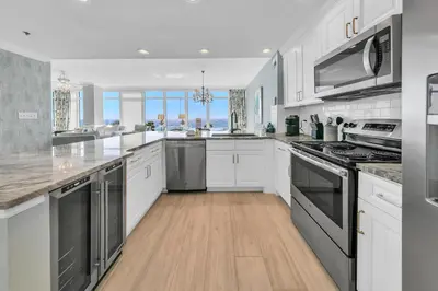 a kitchen with white cabinets and stainless steel appliances at Sterling Beach #301 in Panama City Beach