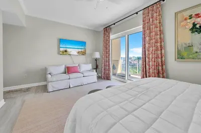 a bedroom with a large bed and a couch at Sterling Beach #301 in Panama City Beach