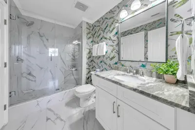 a bathroom with a sink and a toilet and a mirror at Sterling Beach #301 in Panama City Beach