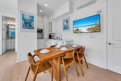 a kitchen and dining room with a wooden table and chairs at Just Breezin' in Santa Rosa Beach