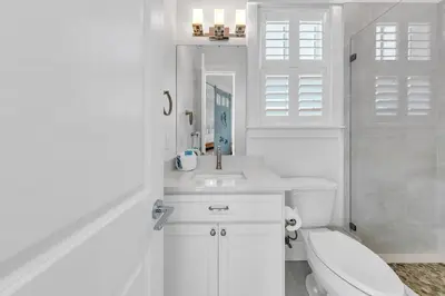 a white bathroom with a toilet and a sink at Just Breezin' in Santa Rosa Beach