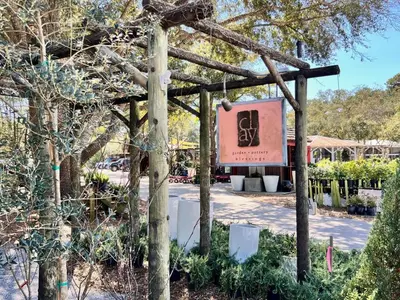 a sign for a garden in a park with trees at Just Breezin' in Santa Rosa Beach