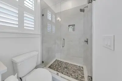 a white bathroom with a shower and a toilet at Just Breezin' in Santa Rosa Beach