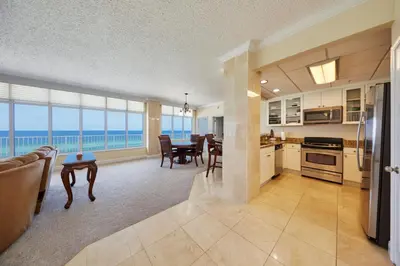 a kitchen and dining room with a view of the ocean at Palmetto Beachfront Hotel, a By The Sea Resort in Panama City Beach