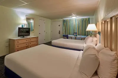 a hotel room with two beds and a television at Palmetto Beachfront Hotel, a By The Sea Resort in Panama City Beach