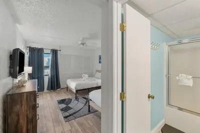 a small room with a bed and a window at Sugar Beach C36 in Panama City Beach