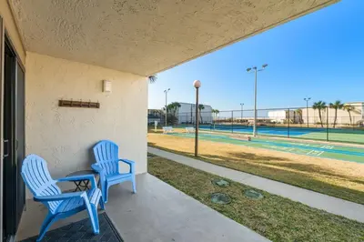 two blue chairs sitting on a porch with a baseball field at Sugar Beach C36 in Panama City Beach