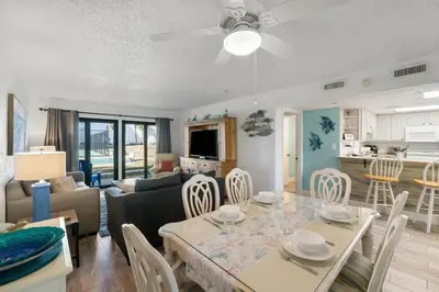 a dining room and living room with a table and chairs at Sugar Beach C36 in Panama City Beach