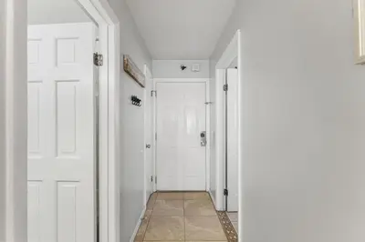 a hallway with two white doors and a tile floor at The Summit 1032 in Panama City Beach