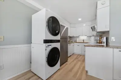 a kitchen with white cabinets and a washer and dryer at The Summit 1222 in Panama City Beach
