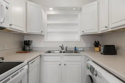 a white kitchen with white cabinets and a sink at The Summit 321 in Panama City Beach