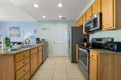 a kitchen with stainless steel appliances and wooden cabinets at Splash 804E in Panama City Beach