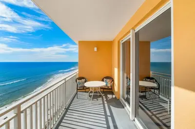 a balcony with tables and chairs and the ocean at Splash 804E in Panama City Beach