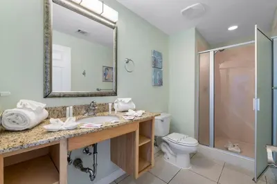 a bathroom with a sink and a toilet and a mirror at Splash 804E in Panama City Beach