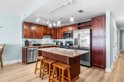 a kitchen with wooden cabinets and stainless steel appliances at Stunning 4BD! Oceanview! Free Beach Chair Service! Sleeps 10! By Dolce Vita Getaways in Panama City Beach