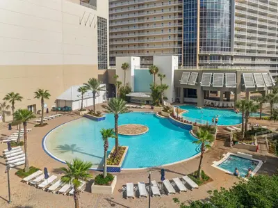 an overhead view of a pool with palm trees and buildings at Stunning 4BD! Oceanview! Free Beach Chair Service! Sleeps 10! By Dolce Vita Getaways in Panama City Beach
