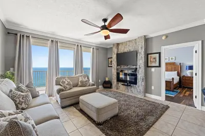 a living room with a couch and a ceiling fan at Treasure Island #1203 by Book That Condo in Panama City Beach