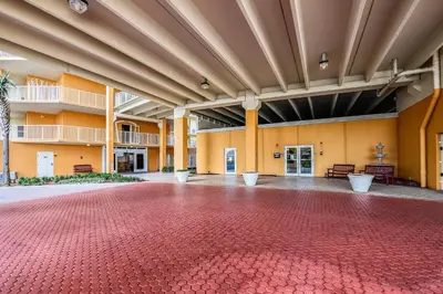 an empty room with a red brick floor in a building at Treasure Island #1203 by Book That Condo in Panama City Beach