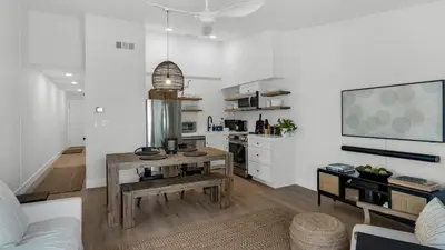 a living room with a table and a kitchen at Beachside Condo 24 Here comes the Sun in Santa Rosa Beach