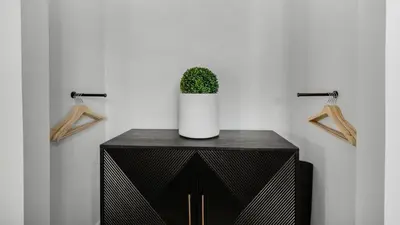 a plant in a white vase on a black cabinet at Beachside Condo 24 Here comes the Sun in Santa Rosa Beach
