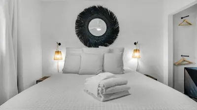 a bedroom with a white bed with towels on it at Beachside Condo 24 Here comes the Sun in Santa Rosa Beach