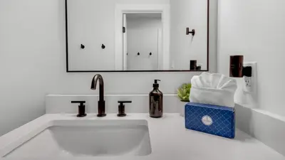 a white bathroom with a sink and a mirror at Beachside Condo 24 Here comes the Sun in Santa Rosa Beach