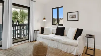 a living room with a white couch and a balcony at Beachside Condo 24 Here comes the Sun in Santa Rosa Beach
