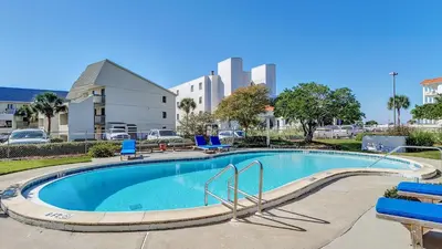 a large swimming pool with blue chairs around it at Beachside Condo 24 Here comes the Sun in Santa Rosa Beach