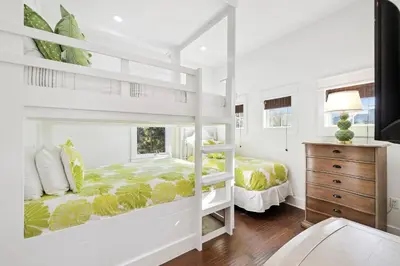 a white bedroom with a bunk bed and a dresser at Greenway Loop by 30A Escapes in Rosemary Beach