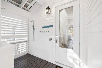 a white bathroom with a white door at Greenway Loop by 30A Escapes in Rosemary Beach